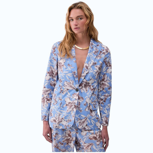 Modella indossa blazer  in popeline azzurro con stampa floreale, rever classico e chiusura a bottone