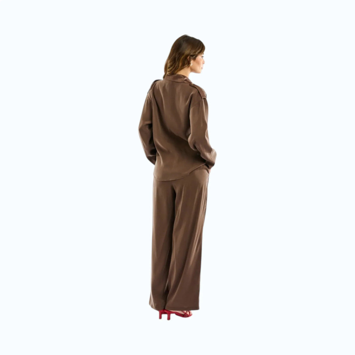 Modella indossa blusa bimaterica marrone con inserti in raso, taschino gioiello e alamari sulle spalle