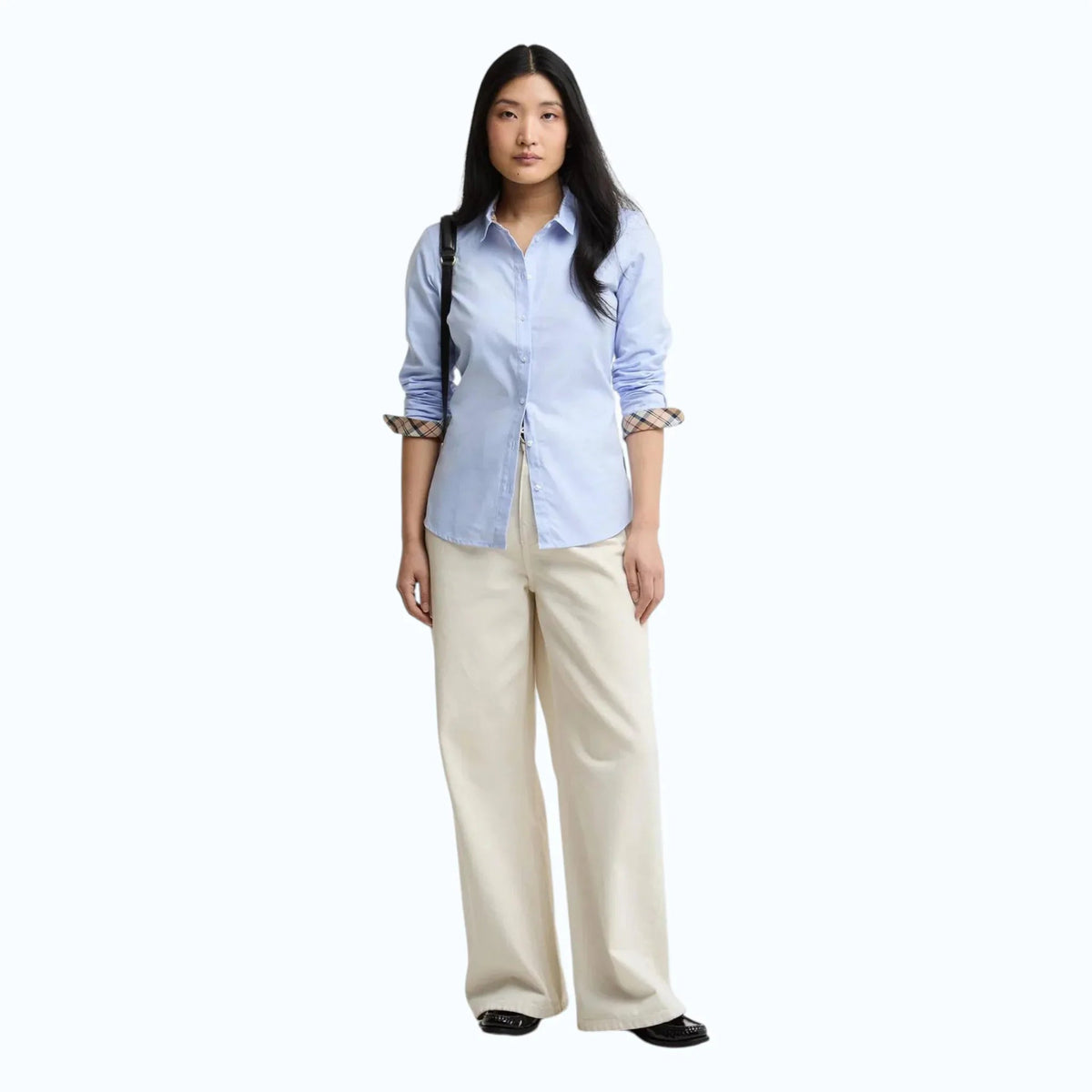 Modella indossa camicia Barbour Derwent in cotone oxford azzurro con dettagli tartan su colletto e polsini