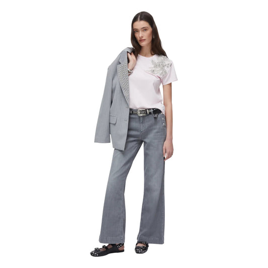 Modella indossa jeans Liu Jo flare a vita alta grigi con bottoni dorati, t-shirt rosa e blazer grigio