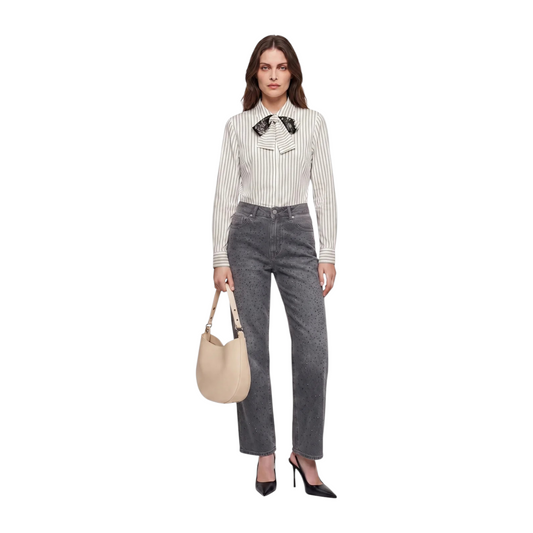 Modella indossa jeans palazzo grigi in denim con strass luminosi, abbinati a camicia a righe e borsa beige