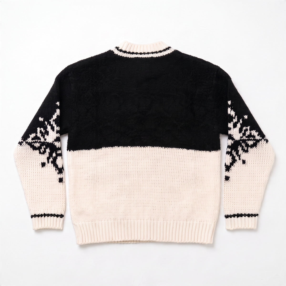 Retro del maglione bicolore nero e bianco panna con motivo fiocco di neve sulle maniche e bordo a costine.
