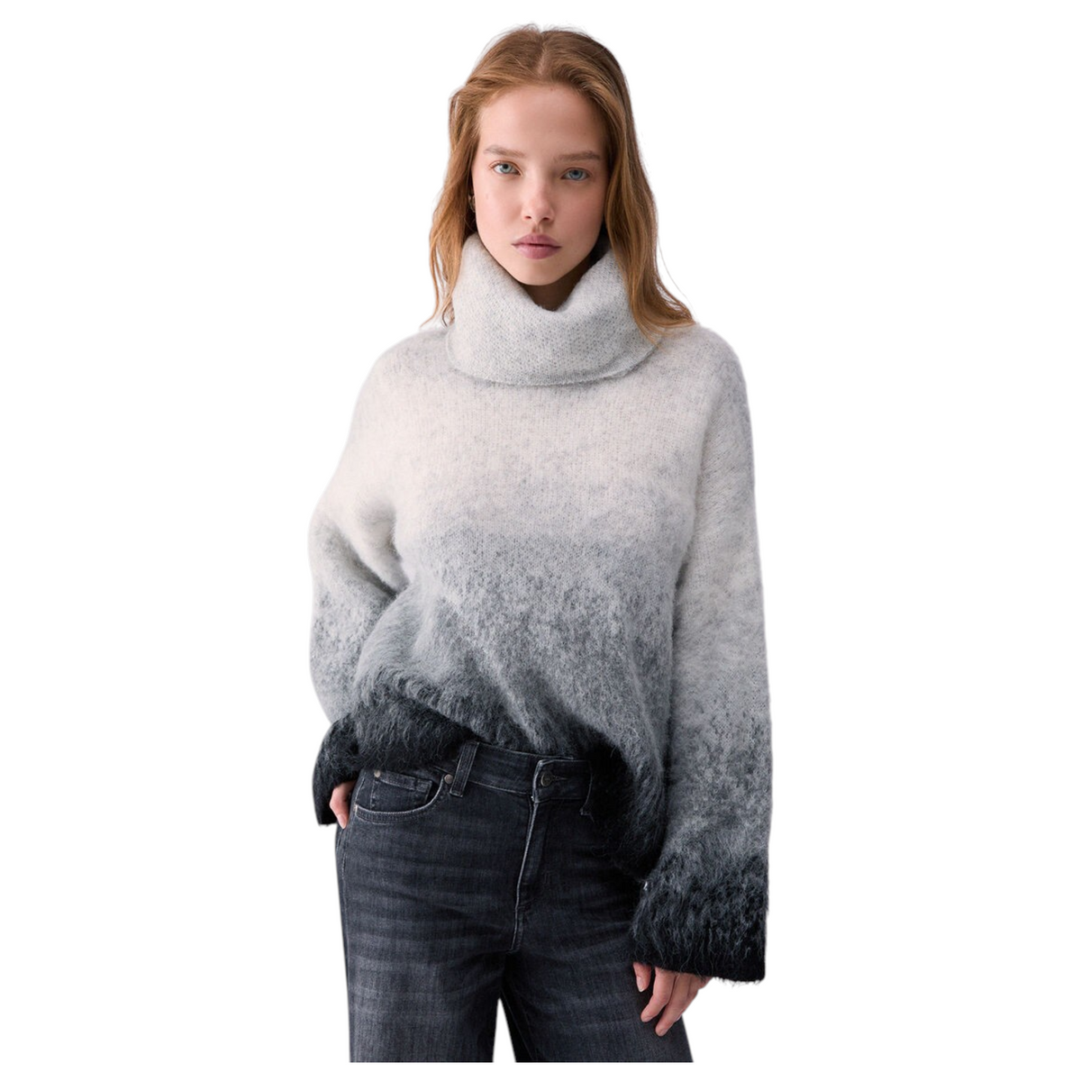 Modella indossa un maglione  a collo alto in lana soffice con sfumatura dal grigio chiaro al nero