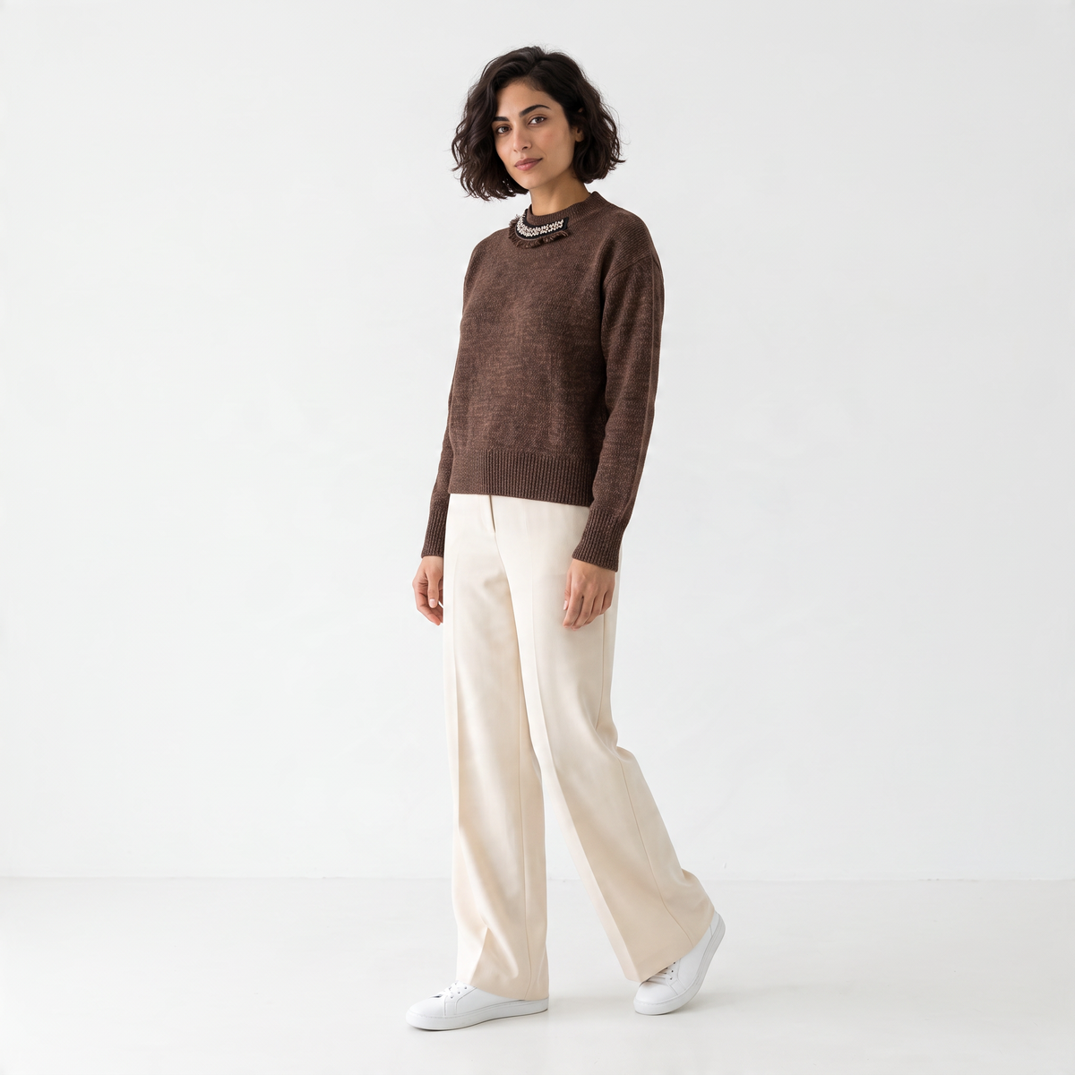 Maglione donna marrone mélange con girocollo gioiello e rifiniture a costine indossato con pantaloni chiari