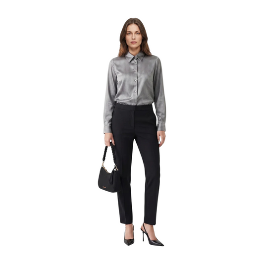 Modella indossa pantaloni neri basic Giorgia&Johns di EmyQ STORE con camicia a righe e borsa a mano