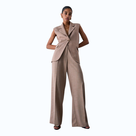 Modella indossa pantaloni palazzo Liu Jo mélange color tortora con gilet coordinato, proposti da EmyQ STORE